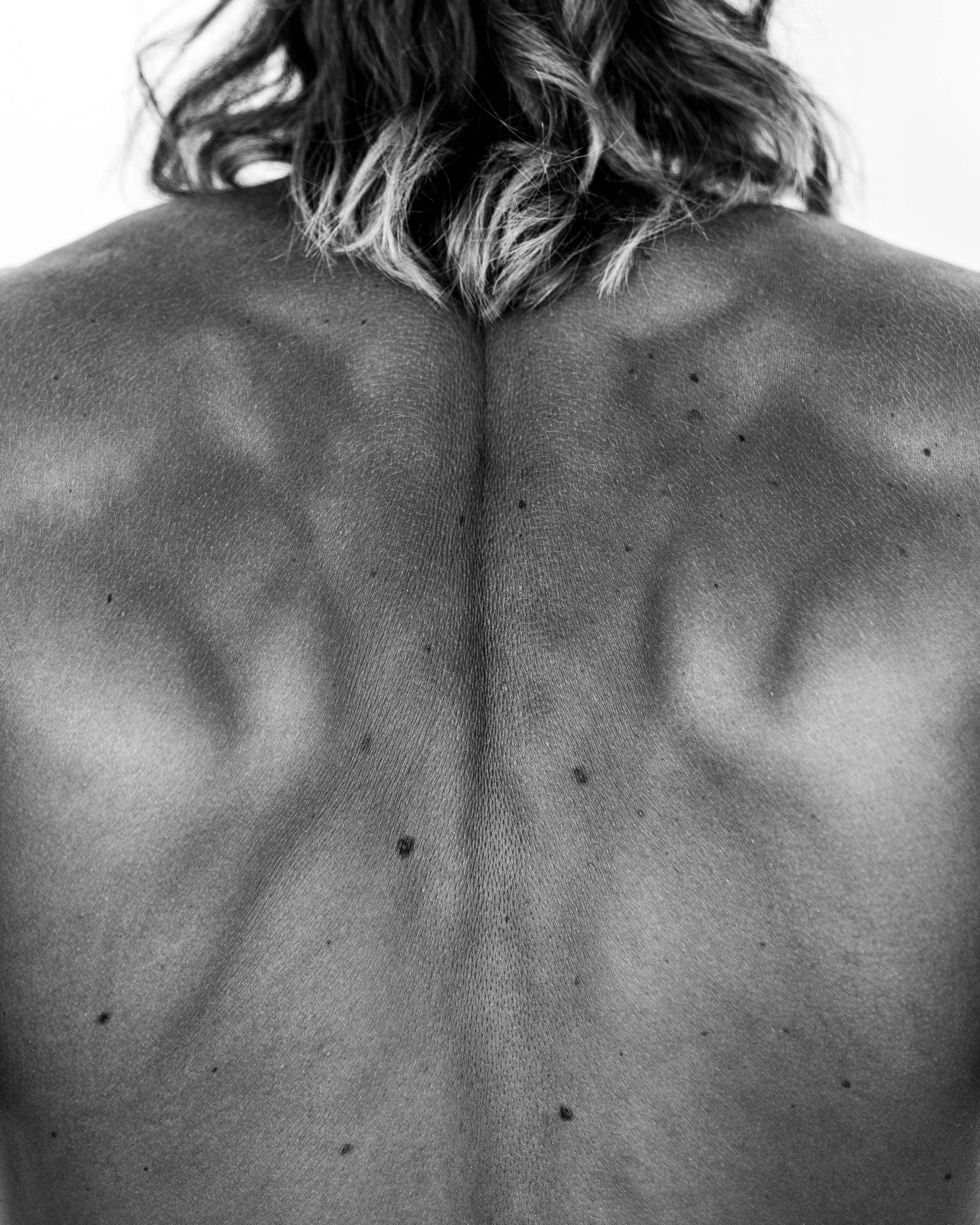 Espalda desnuda de una persona, en blanco y negro